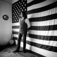 Jerry Garcia with Flag Standing by Herb Greene
